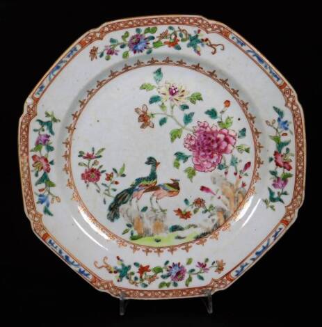 A 18thC Chinese porcelain plate, of octagonal form, polychrome decorated with exotic birds and flowers in a famille rose palette, predominately in pink, green and blue, with an orange border broken by stylized flowers, unmarked, 21cm W.