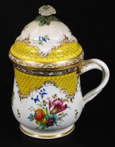 A Berlin large covered can, c1900, decorated with large floral panels and a yellow scale ground with entwined handle, the cover with flower knop, blue underglaze bee hive mark, 19cm H.