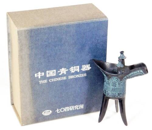 A Chinese bronze finish jue, with shaped body, turned finials and triple spike legs, 15cm H. (boxed)