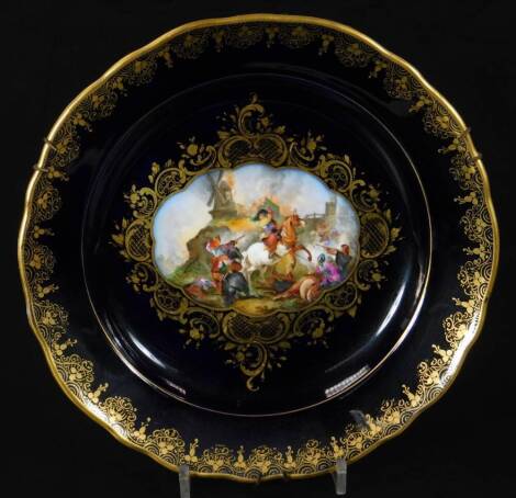 A Meissen porcelain plate, with powder blue ground and gilt highlights, centred with a partially hand painted fete gallant scene, impressed marks beneath, 25cm wide.