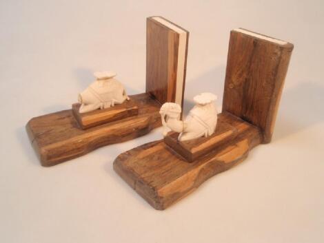 A pair of lignum vitae bookends inset with ivory and mounted with ivory camels (AF)