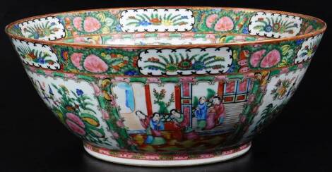 A 19thC Cantonese famille rose punch bowl, of circular form, profusely decorated with panels of figures, birds and flowers, predominantly in pink, green and yellow, unmarked, 37cm Dia.