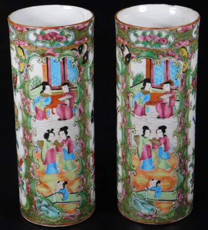 A pair of 19thC Cantonese pottery vases, each of cylindrical form decorated with panels of figures, birds and flowers, predominantly in pink, green and yellow, 23cm H, unmarked. (2)