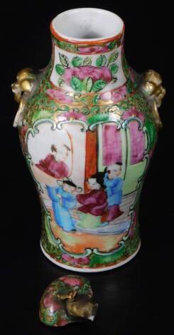 A 19thC Cantonese famiile rose porcelain vase, of shouldered form, with moulded gilt lion and ring handles, decorated with panels of scholars, butterflies and flowers, with a part lid, 15cm H. (AF)