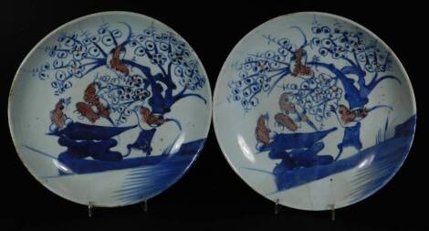 A pair of Chinese porcelain Kangxi style plates, polychrome decorated with birds and trees predominately in blue and brown, unmarked, 24cm Dia.