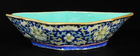 A Chinese porcelain dish, of shaped form, with a floral decoration, heavily set with flowers predominately in blue, yellow and turquoise, with a turquoise interior, red seal mark beneath, 19cm W.