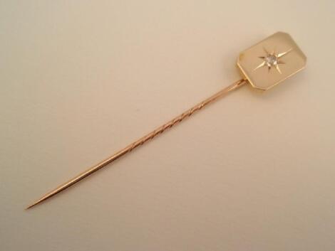 A stick pin set with a small diamond