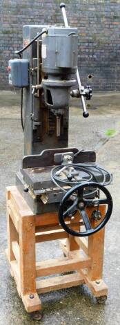 A Multico A1 industrial chisel mortiser, fitted with a Hoover AC motor, the front wheel on an associated pine stand, 150cm H overall.