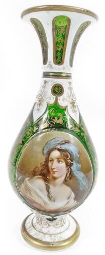 A 19thC Bohemian green flash glass vase, the trumpet stem with milk glass section picked out with gilt highlighted green panels, with further gilt highlights and a front portrait of a lady with a bouquet of flowers to the back, on a circular foot, 26cm H