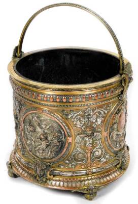 An elaborate 19thC Elkington type metal bucket, the cylindrical body heavily repoussé decorated with panels of classical scenes, cherubs, etc., with an upper and lower acanthus leaf banding, in copper brass and silvered metal, with mask heads, plain handl