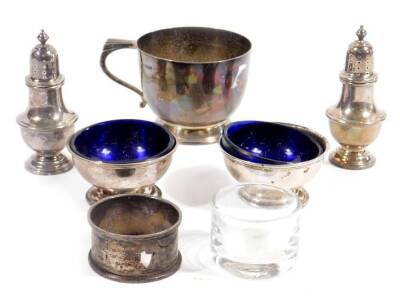 A George V silver christening cup, by Walker & Hall, with stepped S scroll handle, plain body and domed foot, no. 64760, Sheffield 1932, 7cm H, two silver pepper pots, two open salts, silver napkin ring, etc. 10oz all in. (7)