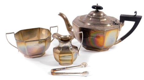 A George VI silver three piece tea service, comprising angular teapot, 17cm H, with ebonised knop and thumb mould handle, on octagonal base, two handled sugar bowl and milk jug, Birmingham 1938, 25cm and a pair of Victorian sugar bows, 26oz. (4)