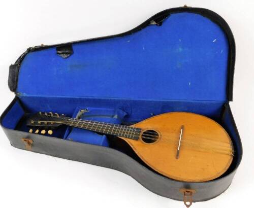 An early 20thC mandolin, of shaped form, with one piece polished back, ebonised end with articulated tuning knops, labelled International College of Music, sold only by The International College of Music, 230 Edgware Road, London W, 61cm W. (cased)