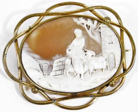 An early 20thC Italian shell cameo, of oval form, set with a lady and figures before castle and trees, with entwined mount and plain pin back, unmarked, 7cm W.