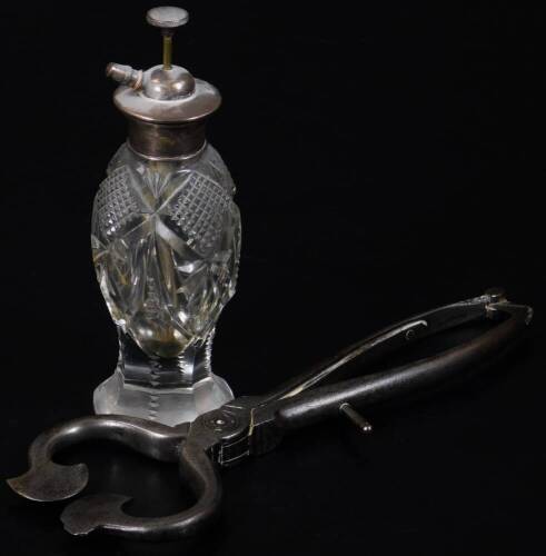 A pair of early 19thC iron sugar cutting tongs, and a cut glass atomizer, with sterling silver lid, 18cm H. (2)