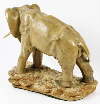 An early 20thC pottery figure of an elephant, on a rock work base, with trunk lowered, baize lined, numbered to the back, 40cm H. - 2