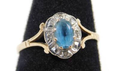 A 9ct gold dress ring, with central section, set with pale blue aquamarine stone, surrounded by tiny diamonds, in platinum setting, with V splayed shoulders, ring size P, 1.8g all in.