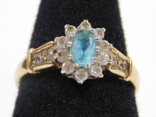 A 9ct gold dress ring, with central floral cluster of pale blue stones, surrounded by imitation diamonds, with paste stone set shoulders, ring size P, 2.6g all in.