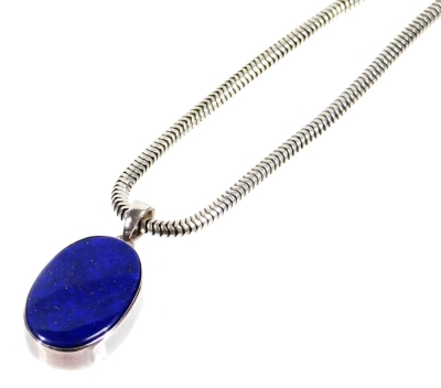 A Claudia Bradby lapis lazuli and silver necklace, with oval pendant set with lapis in rub over silver setting, on fancy link silver chain, 20.9g all in, boxed.