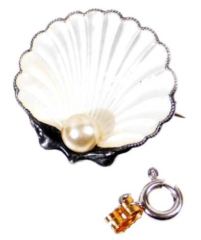 A silver and white enamel clam brooch, set with single cultured pearl to base, shaped as a clam with white enamel decoration, marked to rear made in England sterling silver, 2.5cm wide, 6.7g all in.