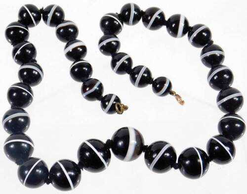 A bullseye agate beaded necklace, with graduated spherical beads, the largest 15mm wide, the smallest 8mm wide, on brass clasp and string necklace, 52cm long overall, 133.8g all in.