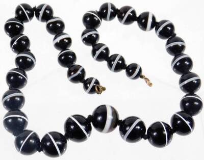 A bullseye agate beaded necklace, with graduated spherical beads, the largest 15mm wide, the smallest 8mm wide, on brass clasp and string necklace, 52cm long overall, 133.8g all in.