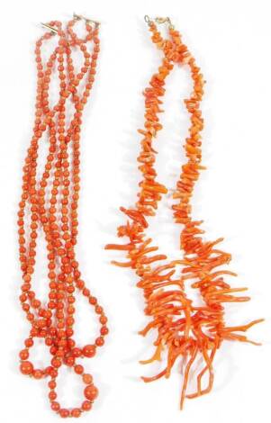 Two coral necklaces, comprising a natural coral necklace with graduated design coral drops, on wire frame, 46cm long overall and a three strand coral beaded necklace with graduated polished spherical beads, gold plated clasp, 46cm long overall. (2)