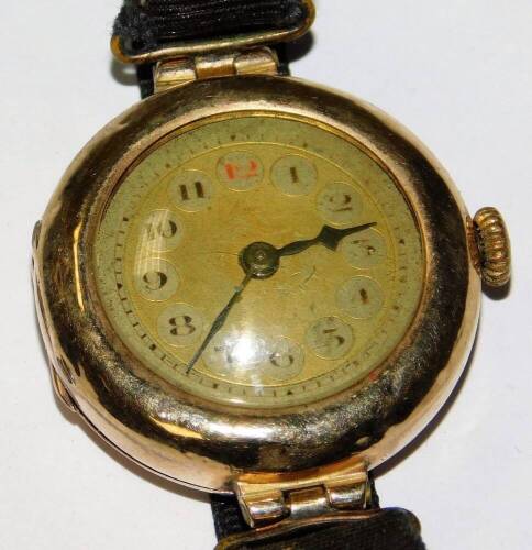 A ladies wristwatch, with a gold coloured dial and cloth strap, yellow metal, stamped 9K