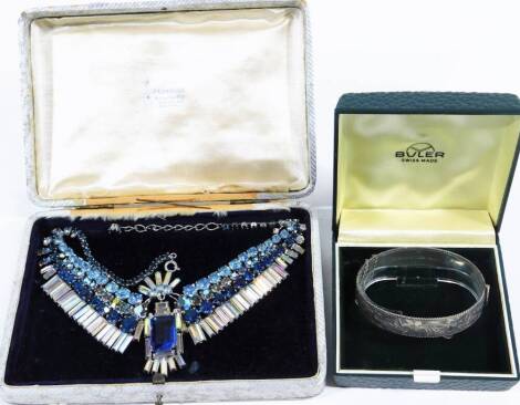 Two items of jewellery, to include a Victorian silver bangle, with etched floral design, in retailer Buler fitted box, and a vintage elaborate costume jewellery necklace, with blue and white paste stones. (2)