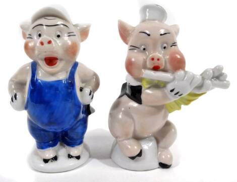 A Walt Disney Three Little Pigs match holder, with blue braces with open back, printed marks beneath, 11cm H, and another playing flute. (2)