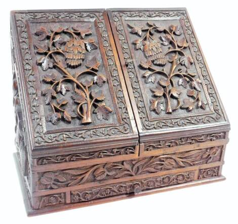 An Edwardian carved oak stationery box, the articulated front set with many leaves with an outer leaf and berry border, raised above a single drawer with inner compartment, with a fitted interior, 29cm H, 36cm W, 20cm D.