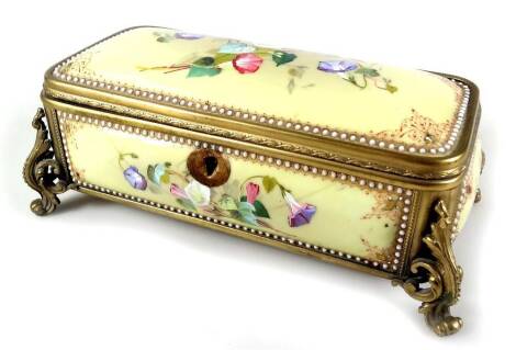 An oblong gilt metal casket, with panels of flowers, polychrome decorated predominately in pink, blue and white, on a yellow ground with a bead work outline, probably French, unmarked, 21cm W.