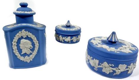 Various Wedgwood blue Jasperware, comprising a teapoy, of shouldered form with lid, the main body raised with classical figure heads and garlands, 20cm H, a lidded powder jar and another smaller. (3)