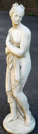 A classical concrete statue of a lady, semi clad in flowing robes, on circular base, 127cm H.