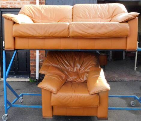 A two piece lounge suite, in tangerine leather, comprising of a two seater settee, 190cm W and an armchair. (2) The upholstery in this lot does not comply with the 1988 (Fire & Fire Furnishing) Regulations, unless sold to a known exporter or upholsterer 