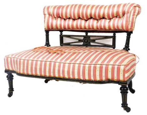 An Edwardian ebonised salon settee, of small proportion, the scroll back and seat upholstered in a Regency pink and white stripe with floral highlights, on turned front legs, with a pierced rectangular back splat, 74cm H, 99cm W, 59cm D.