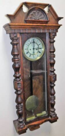 A late 19thC walnut cased Vienna wall clock, the cornice with a carved shell and scroll motif, above a glazed case flanked by quarter columns, with 17cm Dia. Roman numeric dial, with two weights and 8-day movement, 112cm H.