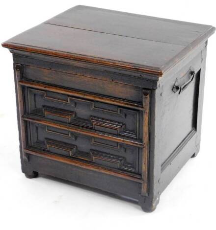 A late 17thC/early 18thC oak box commode, the hinged rectangular lid with a moulded edge enclosing a vacant interior, with a panelled front and later iron carrying handles to the sides, 46cm H, 51cm W, 43cm D.