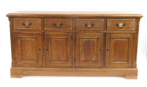 A 20thC pine dresser base, the overhanging top raised above four drawers and panelled cupboards beneath, on ogee bracket feet, 94cm H, 180cm W, 47cm D.