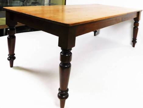 A 19thC plank top pine kitchen table, of large proportions, the rounded top raised on heavy turned legs, 74cm H, 215cm W, 105cm D.