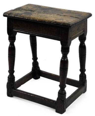 A 17thC oak joint stool, the rectangular top with moulded edge on turned supports with stretchers, carved with the initials ER, the top 45cm x27cm.