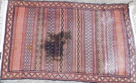 A flat weave rug, with a geometric design in pink, black and white, etc, with fringed ends (AF), 144cm x 90cm.