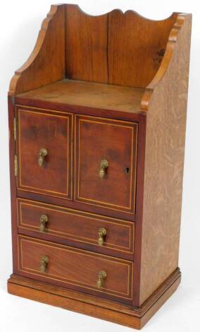 An Edwardian oak hanging cabinet, the galleried top raised above two cupboards and two drawers, on a moulded base, 70cm H, 38cm W, 24cm D.