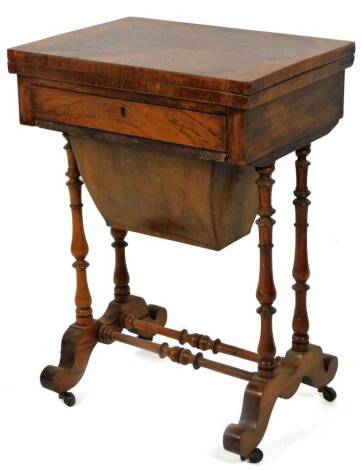 A late Victorian walnut workbox, of rectangular form, with pull out sewing drawer, on turned legs terminating in scroll feet with castors, joined by a turned stretcher, 73cm H, 52cm W, 38cm D.