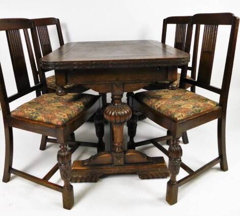 An early 20thC oak draw leaf table, the rounded top raised on heavy globular supports joined by a plain H stretcher, when closed 75cm H, 104cm W, 85cm D, with four dining chairs.