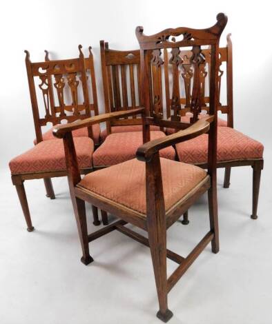 Six Edwardian oak Arts & Crafts dining chairs, each with horizontal heart and pierced vertical back splats, overstuffed seats in fleur de lys silk material, on tapering turned cylindrical legs, 106cm H, and a similar Liberty's type oak carver chair, with 