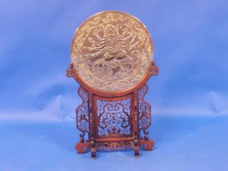 A Chinese bronze circular plaque depicting a buddhistic figure seated on