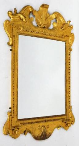 A gilt wood mirror, with Princes of Wales feather and scroll finial, above a bevel glass flanked by scroll sides with a shell carving to the under section, 115cm H, 72cm W.