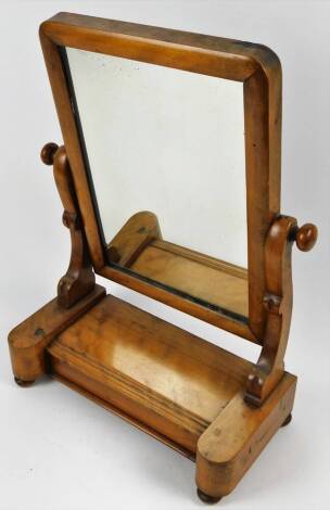 A late Victorian table mirror, the shaped glass flanked by S scroll supports on an inverted platform base terminating in compressed bun feet, 53cm H, 39cm W, 19cm D.