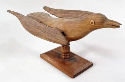 A Pitcairn Cain Christian Folk Art wooden carving, of a bird, the wings named Made by Cain Christian a descendent of Fletcher Christian of The HMS Bounty, on a removable base, 25cm W.